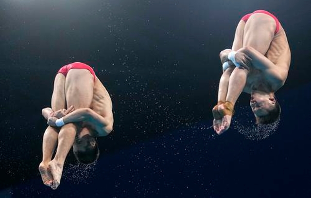 东京奥运会跳水男子双人十米跳台决赛，中国选手曹缘/陈艾森在比赛中。新华社记者 许畅 摄
