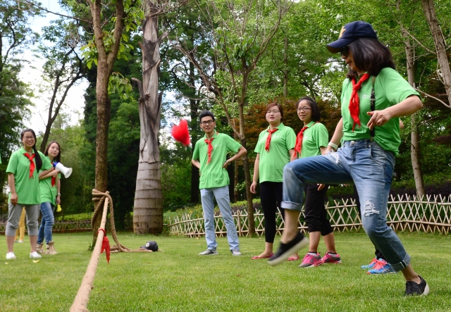 2016年6月1日。老中少在新华公园里过儿童节，此图为：踢毽子的青年人