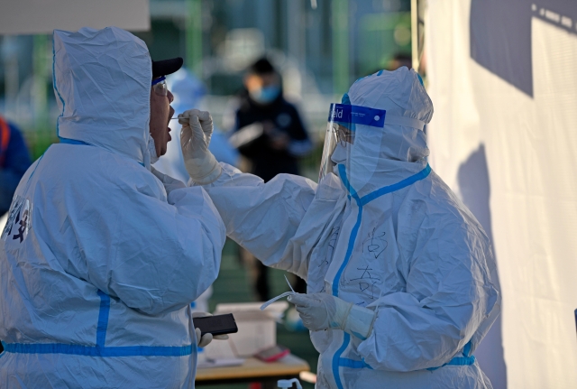 天津医务人员在为现场执勤的公安民警进行核酸采样（1月10日摄）。新华社记者 赵子硕 摄