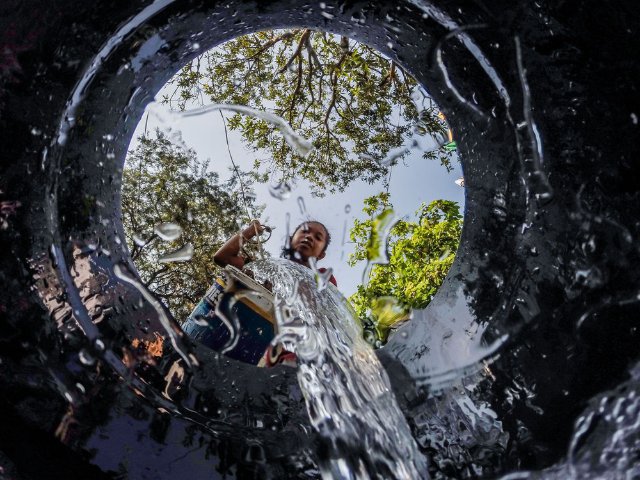 3月22日，在菲律宾奎松市的一处水井附近，居民将水倒入桶里。新华社发（乌马利摄）.jpg