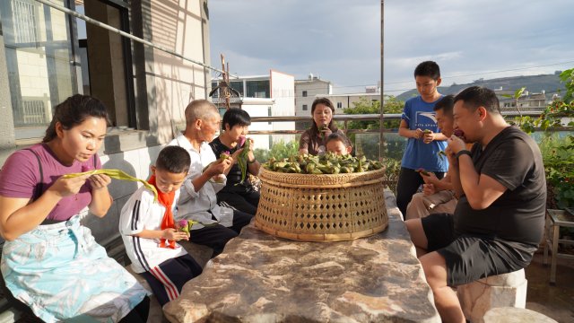 一家人围坐在一起吃彩色粽子，无比惬意。6月12日摄。.JPG