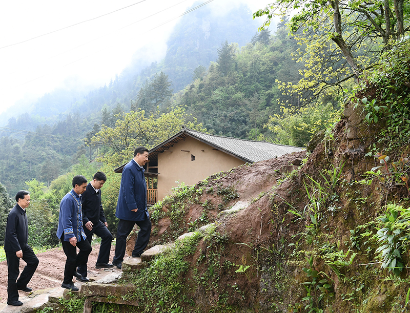 2019年4月15日，在石柱土家族自治县中益乡华溪村，习近平总书记踏着湿滑的石阶登上陡坡，前往贫困户谭登周家看望。