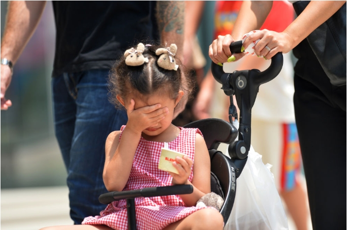 4月3日，一名儿童在泰国曼谷街头用手遮阳。新华社发（拉亨摄）.png