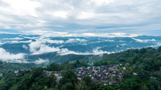 被山林与茶园环绕的景迈山翁基古寨一景（无人机照片，9月17日摄）。
